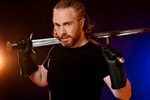 Headshot of Matthew Crawford holding sword